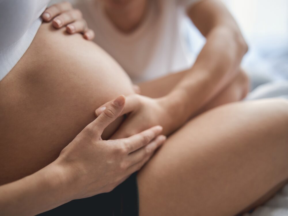 Future mom and dad are touching pregnant tummy